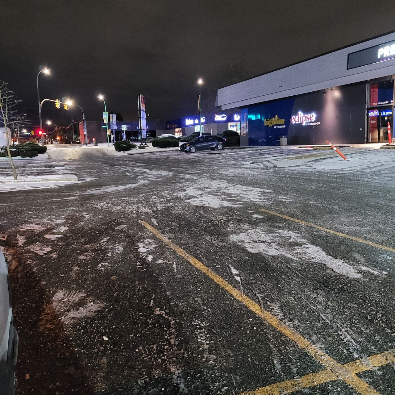 PlowWow Kingsway building snow-removal photograph Snow-covered commercial parking area and building frontage at 5549 Kingsway in Burnaby, photographed at night